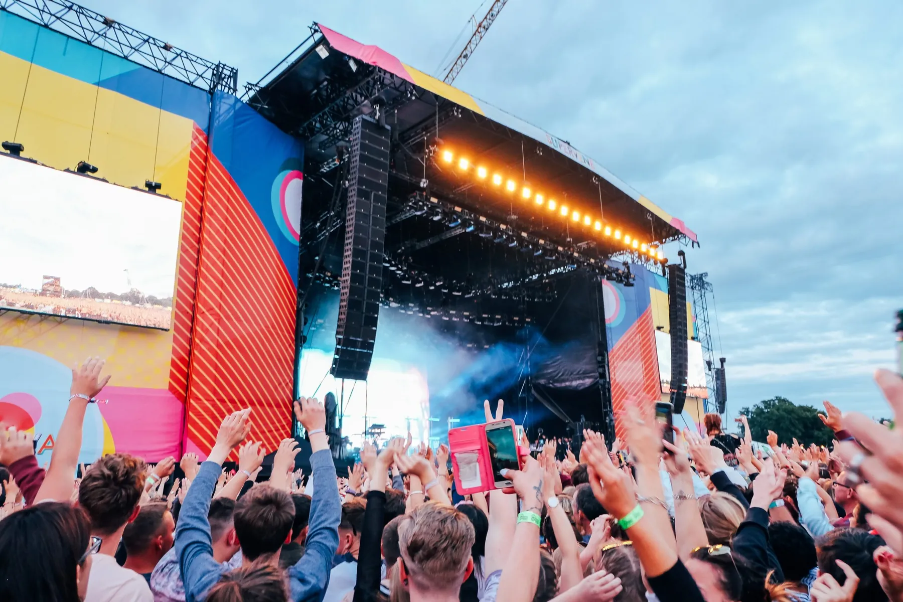 Outdoor festival stage with a crowd dancing in front of it