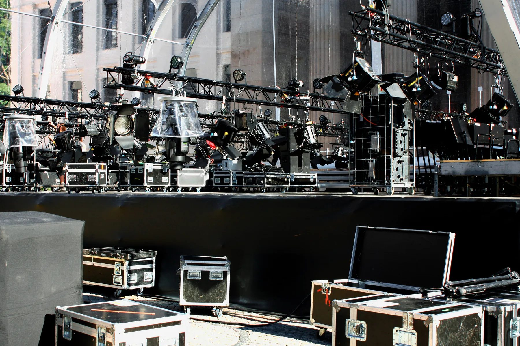 Equipment staged before an event — amp racks, road cases and cable runs laid out at the load-in position
